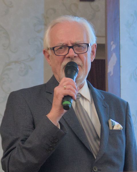 James Loader looking at the camera and speaking into a microphone