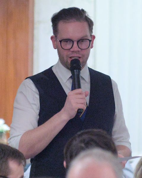 Luke Anderson speaking into a microphone